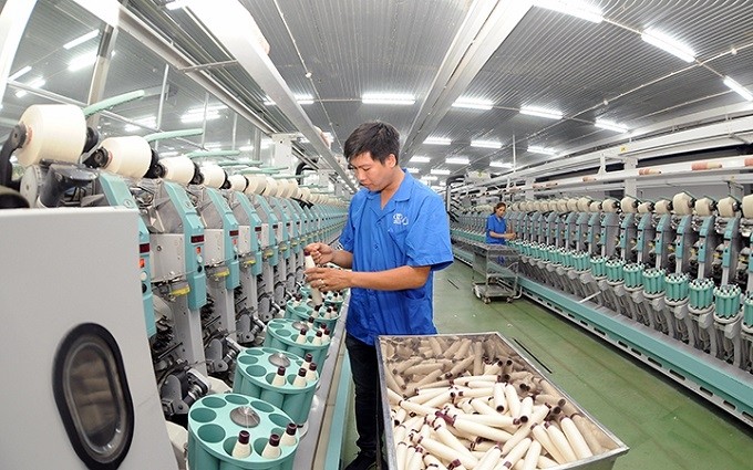 Workers of the 8/3 Textile Company Limited operating fibre production lines. (Photo: NDO/Quang Minh)