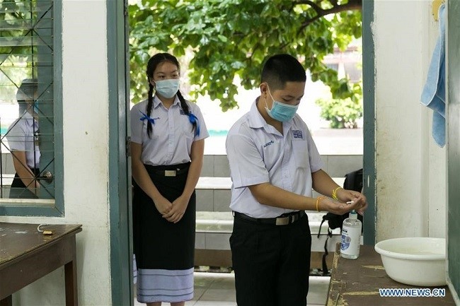 (Illustrative image). Students wearing masks line up for washing hands at a school in Vientiane, Laos, May 19, 2020. (Photo: Xinhua)