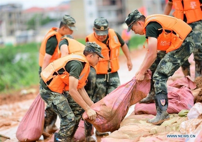  Armed policemen move sand bags for dyke reinforcement in Poyang County, east China's Jiangxi Province, July 12, 2020. (Photo: Xinhua)