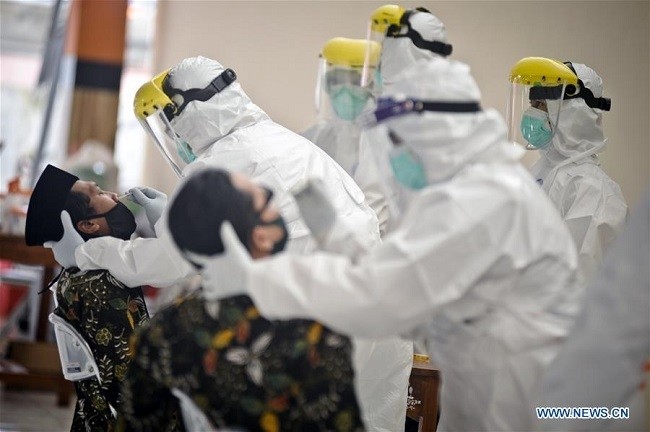 Medical workers collect swab samples from people in Yogyakarta, Indonesia, on July 29, 2020. The COVID-19 cases in Indonesia rose by 2,381 within one day to 104,432, with the death toll adding by 74 to 4,975, the Health Ministry said on Wednesday. (Photo: Xinhua)