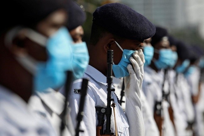 A member of Kolkata police adjusts his face mask as he takes part in rehearsal for the Independence Day parade, after authorities eased lockdown restrictions that were imposed to slow the spread of the coronavirus disease (COVID-19), in Kolkata, August 11, 2020. (Photo: Reuters)
