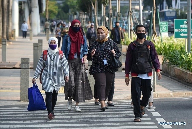People wearing face masks cross a street in Jakarta, Indonesia, Aug. 19, 2020. The COVID-19 cases in Indonesia rose by 1,902 within one day to 144,945, with the death toll adding by 69 to 6,346, the Health Ministry said on Wednesday. (Photo: Xinhua)