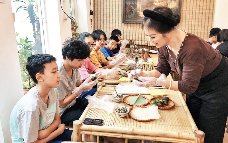 Ms. Nguyen Thi Hien instructs children on how to make Hanoi’s traditional cold snail noodle soup. (Photo: NDO/Giang Nam)