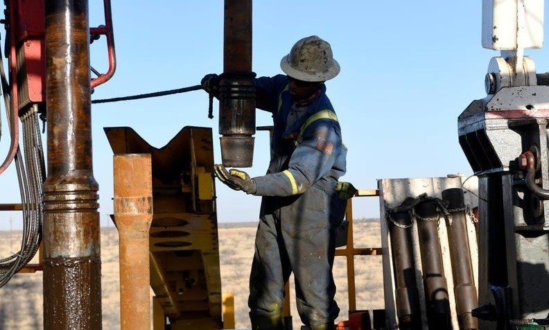 An oil worker removes a thread cap from a piece of drill pipe on a drilling lease owned by Elevation Resources near Midland, Texas, U.S., February 12, 2019. (Photo: Reuters)