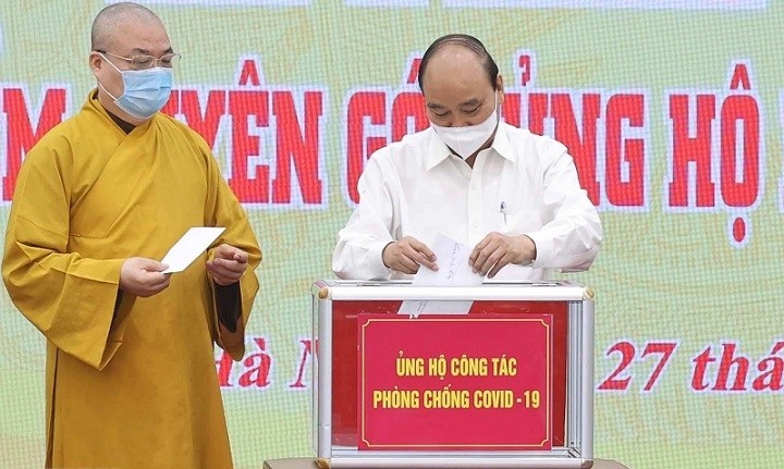 President Nguyen Xuan Phuc (right) makes a donation at the launch of the fundraising campaign on May 27. (Photo: VNA)