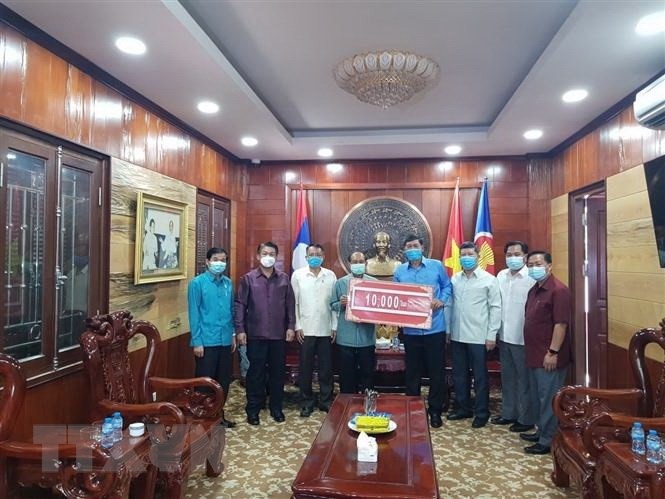 Representatives from the Lao province of Luang Prabang hand over their financial donations to support the COVID-19 fight in Vietnam's Dien Bien province. (Photo: VNA)
